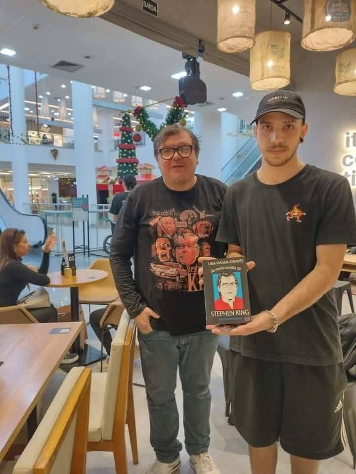J. Angelini com leitor em sessão de autógrafos em shopping