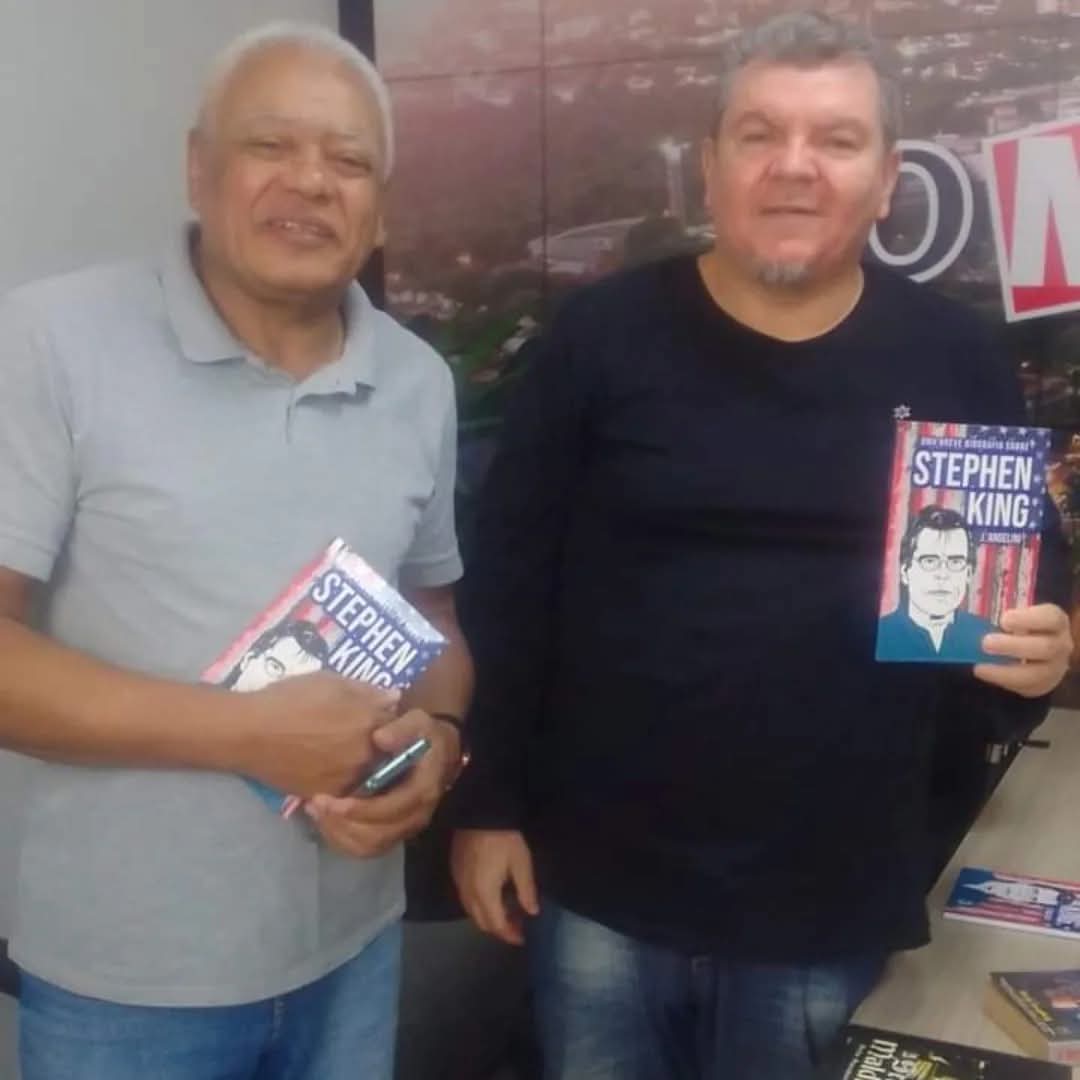 J. Angelini com leitor em evento de autógrafos