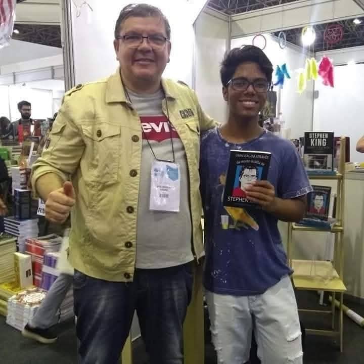 J. Angelini com leitor em feira de livros